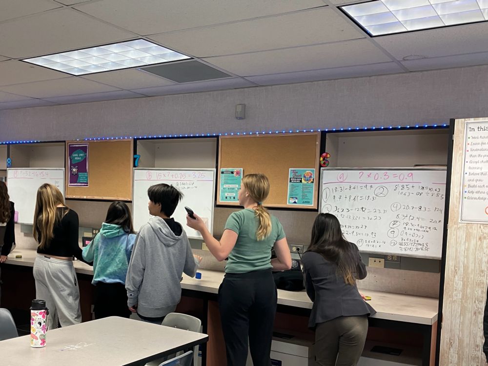 Students at whiteboards working on problems
