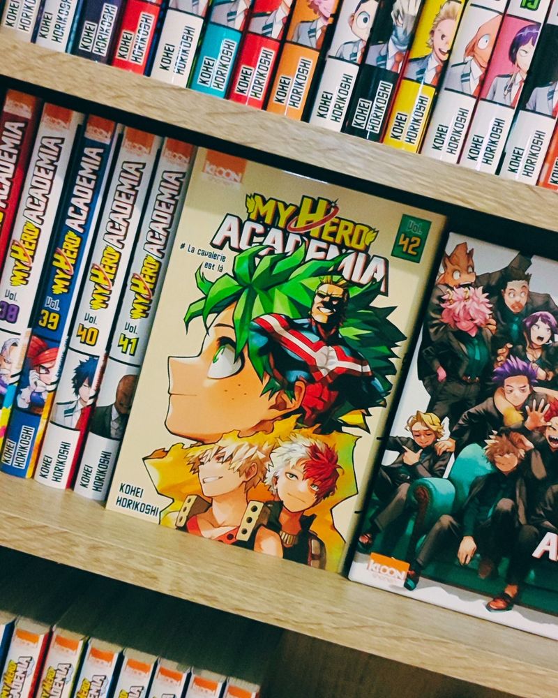 Photo volontairement mal cadrée de ma collection de manga My Hero Academia avec un focus sur le tome 42 où on voit Deku, Bakugo, Shoto et All Might