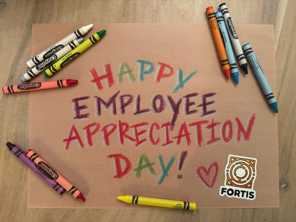 A hand written piece of paper saying happy employee appreciation day with multicoloured crayons scattered around