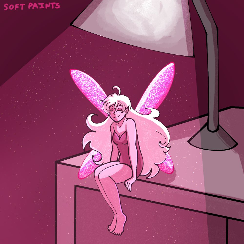 A fairy is sitting on a desk with a lamp beaming down on them. They look content.