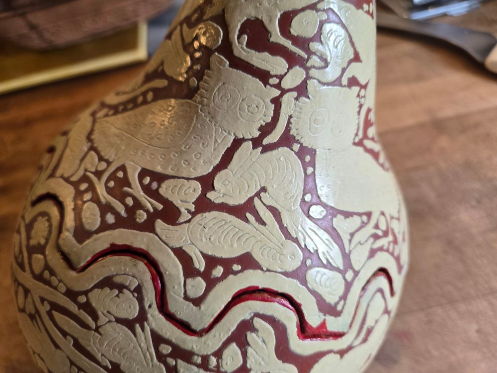 A detail of the gourd showing a pair of owls and other animals. Fine details of eyes, beaks, feathers, etc. were incited into the work before it was painted. The unknown artist may have been inspired by cameo carving.