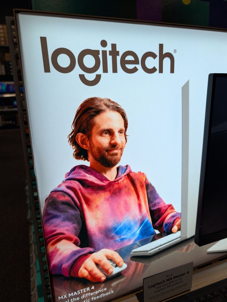 It's a photo of a Logitech advertisement and the model is a white guy with moderate link brown hair beard and this really wild tie-dye hoodie on... The whole aesthetic is very made up in a lab. 