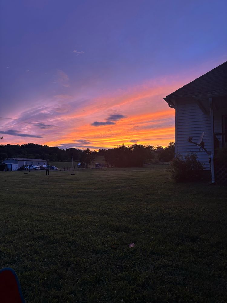 Orange bands of clouds though a dark sky which is rested over over hills 