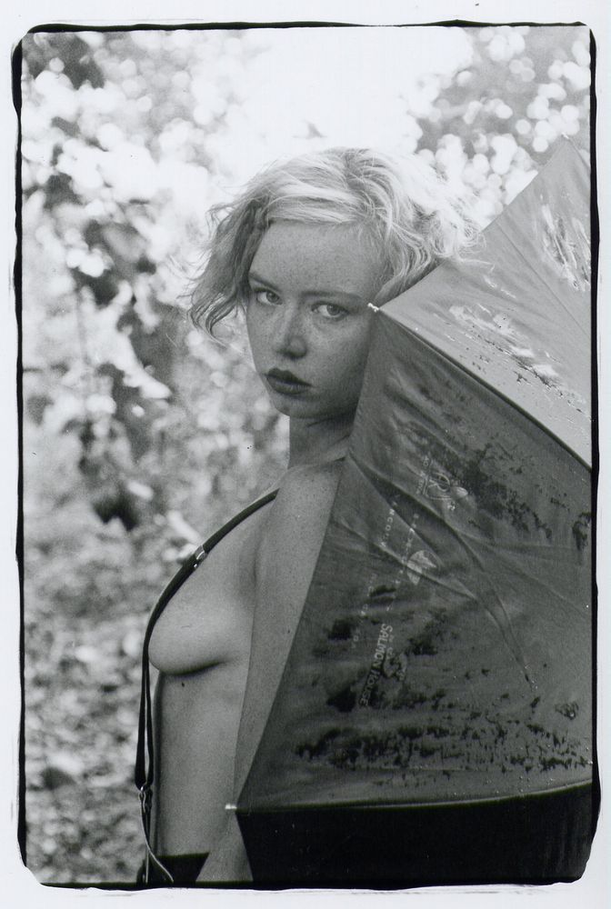 sparklefaerie topless, side on, with a wet umbrella behind her
