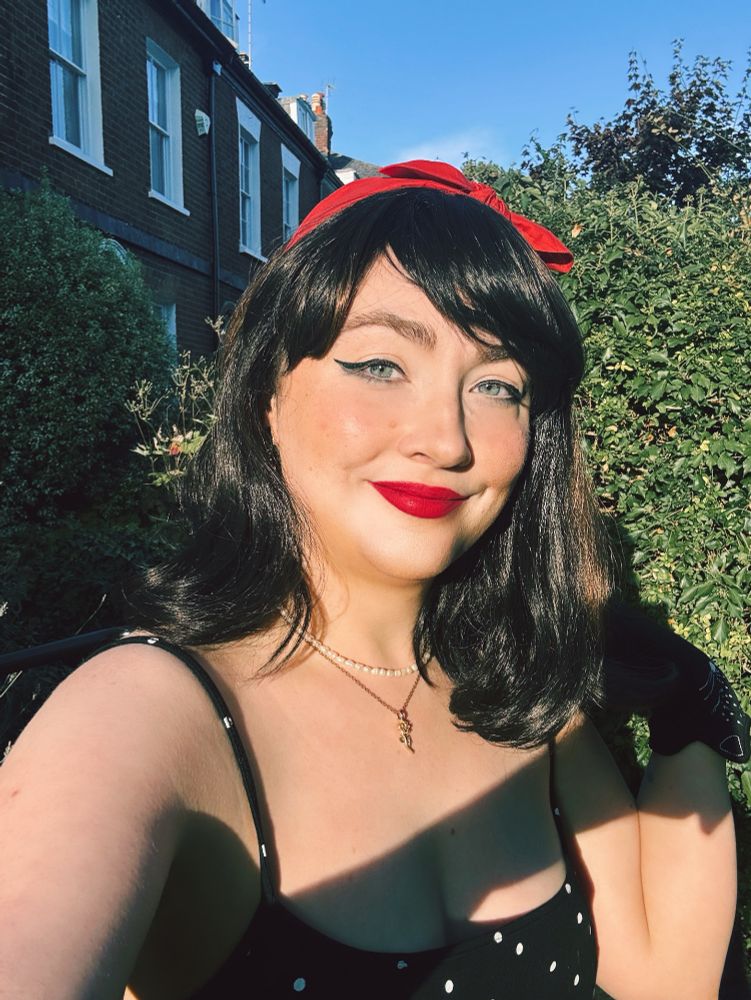 A photograph of Ellena wearing a black polka dot jumpsuit. 