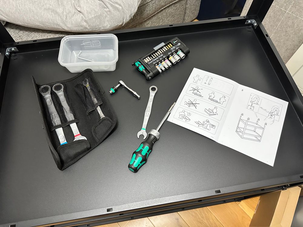 An almost-complete Ikea Bror workbench/trolley, upside down. Resting on the bottom shelf is a selection of Wera hand tools, including a 13mm “Joker” combo ratchet spanner. (That’s a “wrench” if you’re American.) There’s also a Kraftform screwdriver and a Tool Check PLUS bit/driver set. 