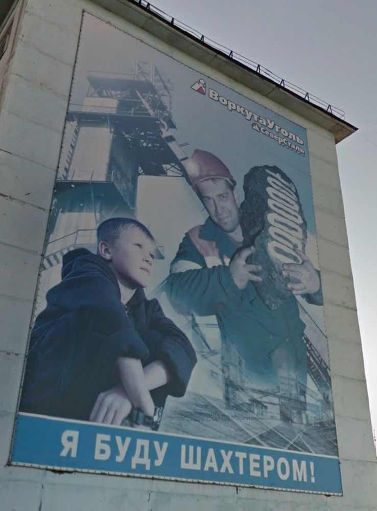 A child looking up at an adult mine worker