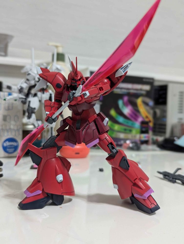 red and maroon monoeye mecha model kit holding a double sided laser sword