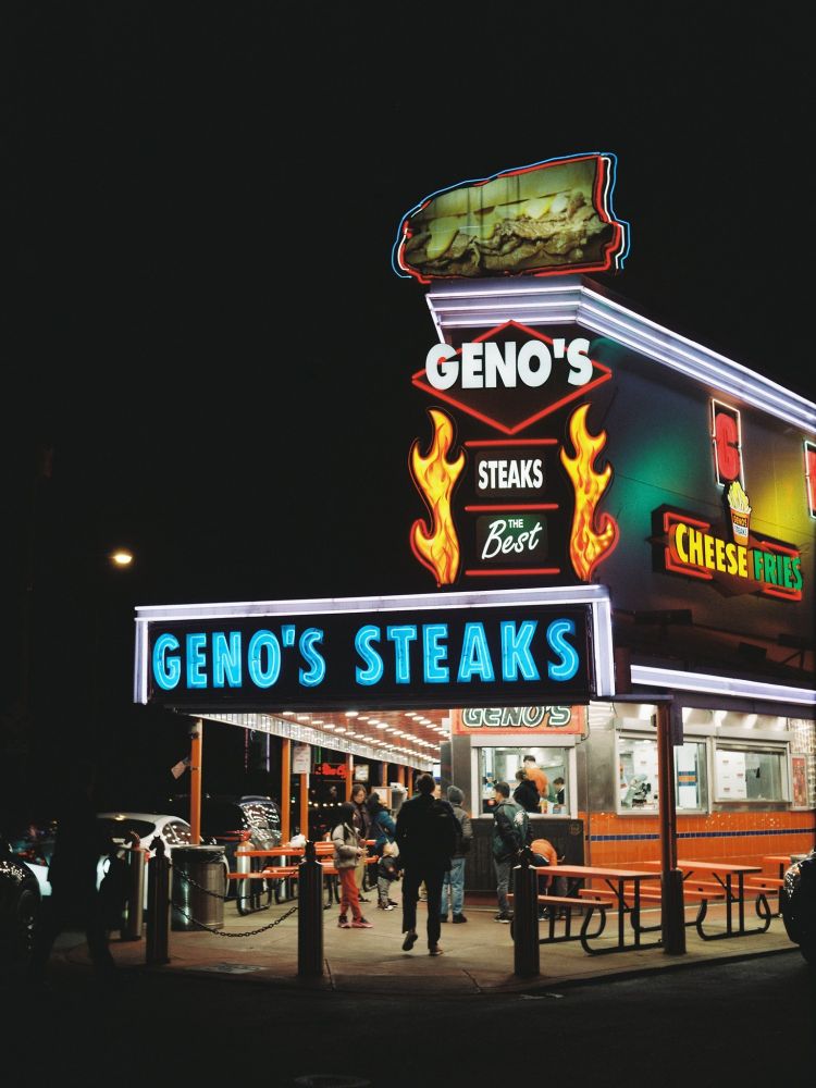 Nighttime color photo of the iconic neon sign of Geno's Steaks in South Philadelphia.