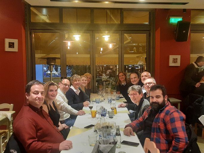 AntiDop team members sitting at a long dinner table, enjoying food and conversation in a relaxed atmosphere.