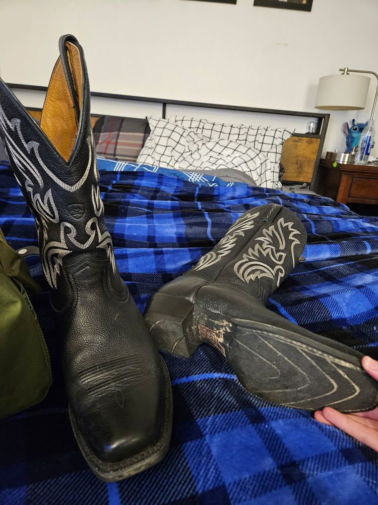 A picture of old thrifted black cowboy boots