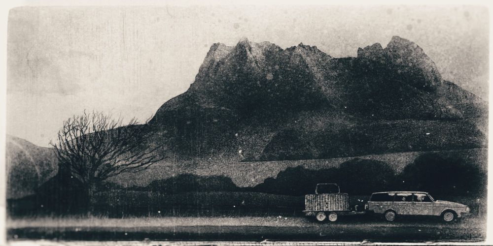 A black and white illustration of a Volvo 240 towing a hot air balloon trailer past the Scottish mountain Stac Pollaidh