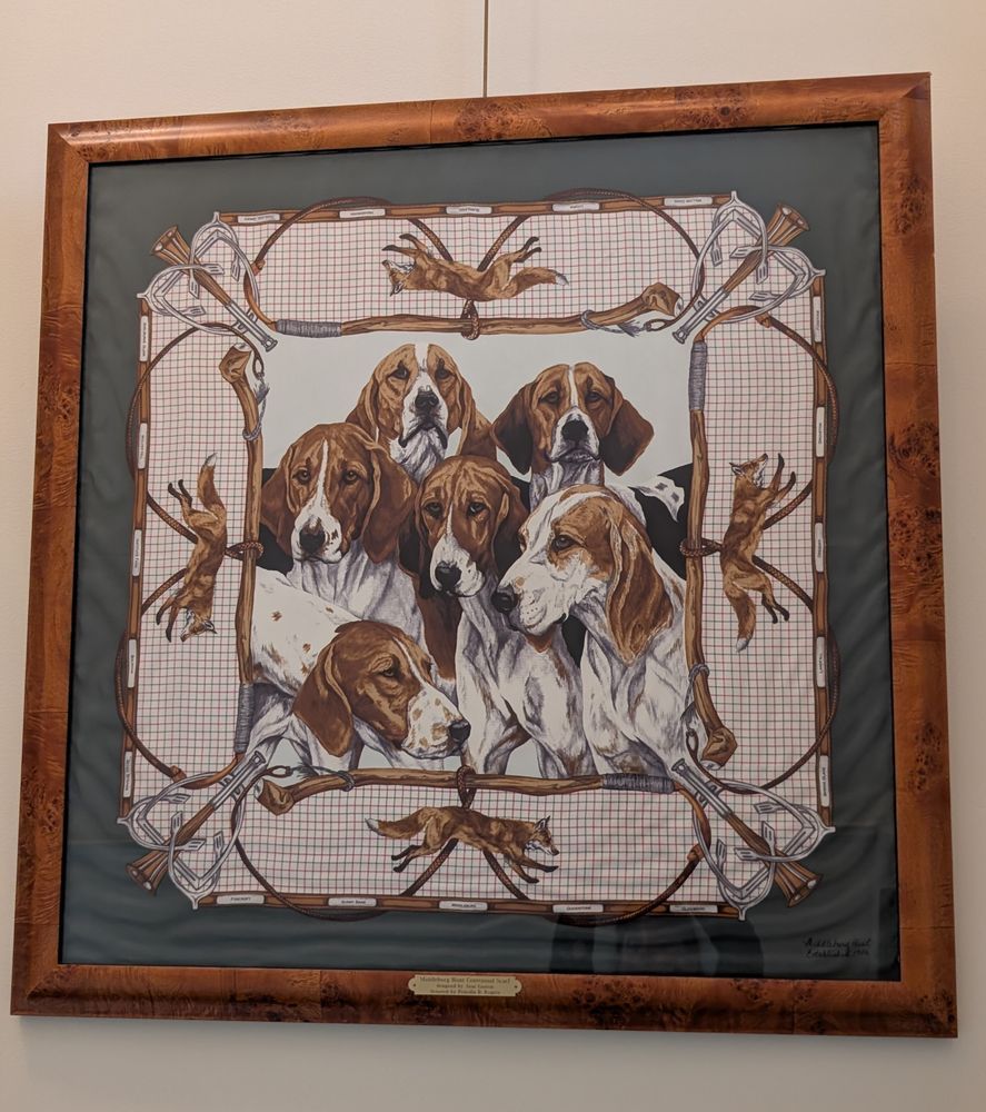 framed square textile depicting six foxhounds. The border is comprised of four foxes and various elements from foxhunting 