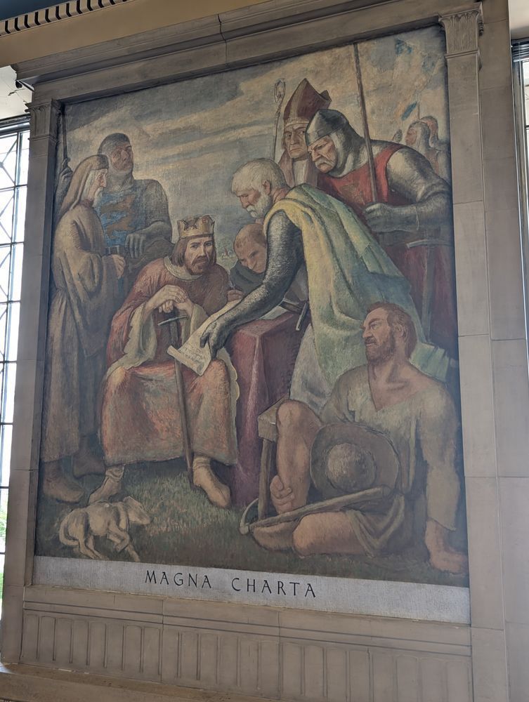 mural showing a group of people and a dog lying in the foreground.