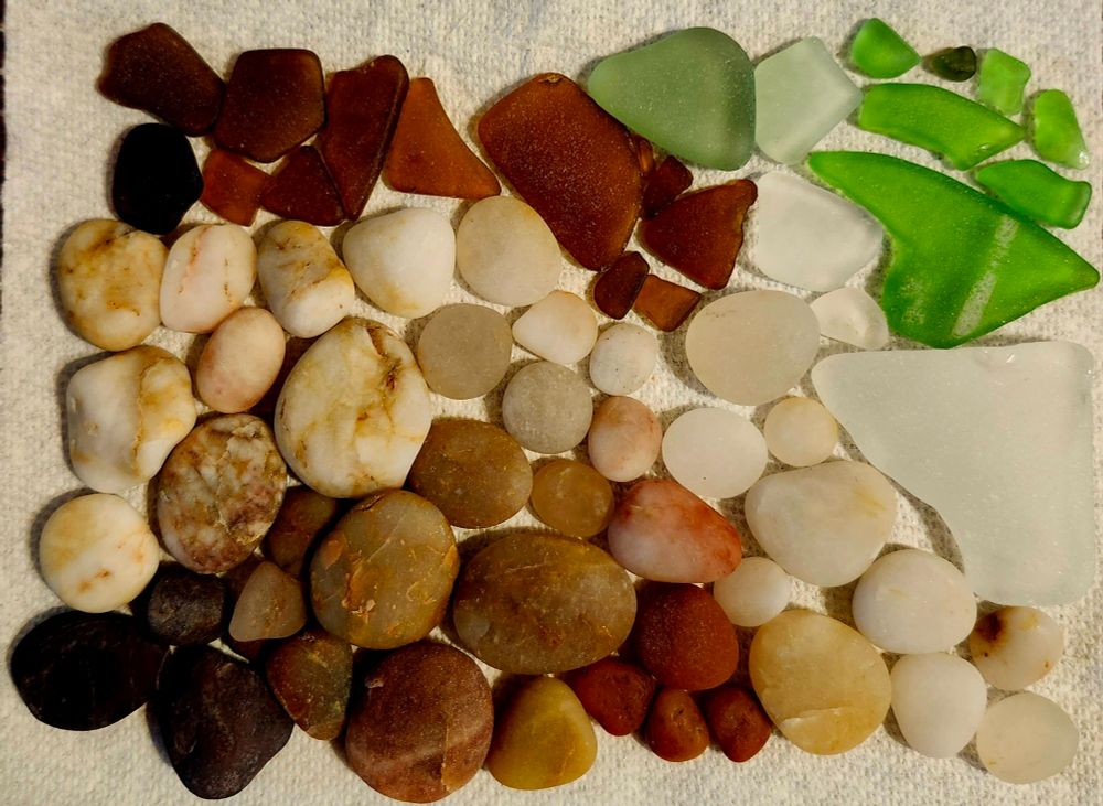 A paper towel with cool pebbles, rocks, and sea glass displayed.