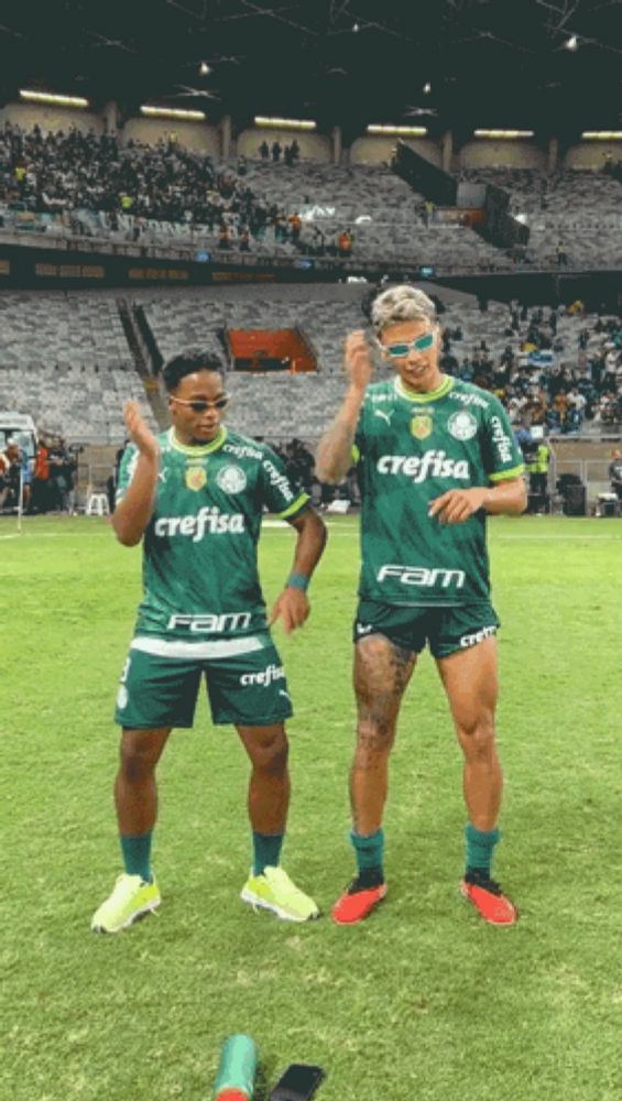 two soccer players with crefisa on their shirts stand on the field