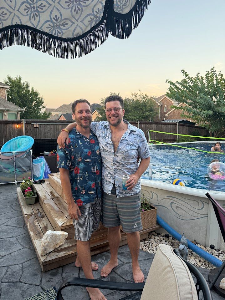 Two sexy dads in swim trunks and Hawaiian shirts enjoying a pool party