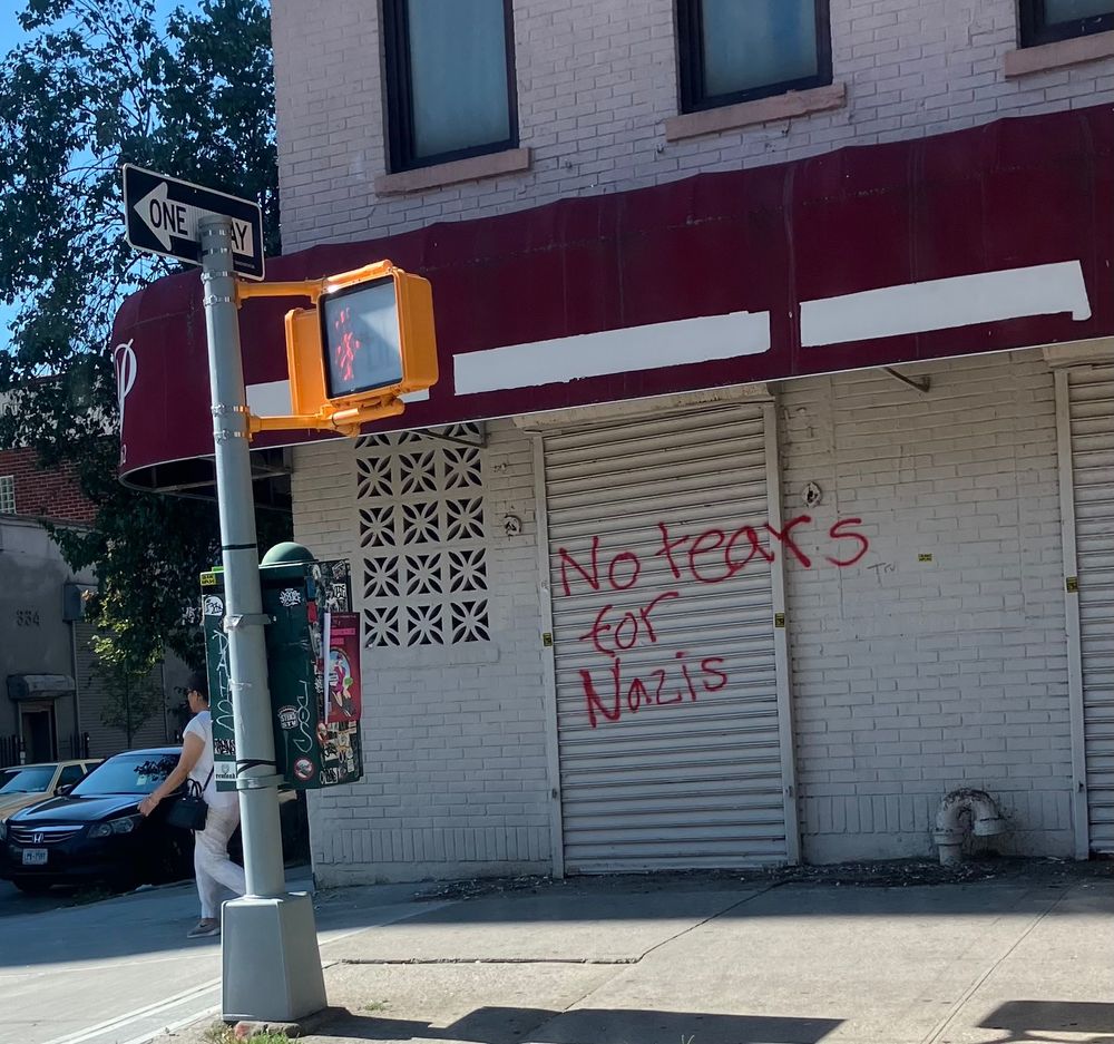 Graffiti on a closed store front. 
"No tears for Nazis"