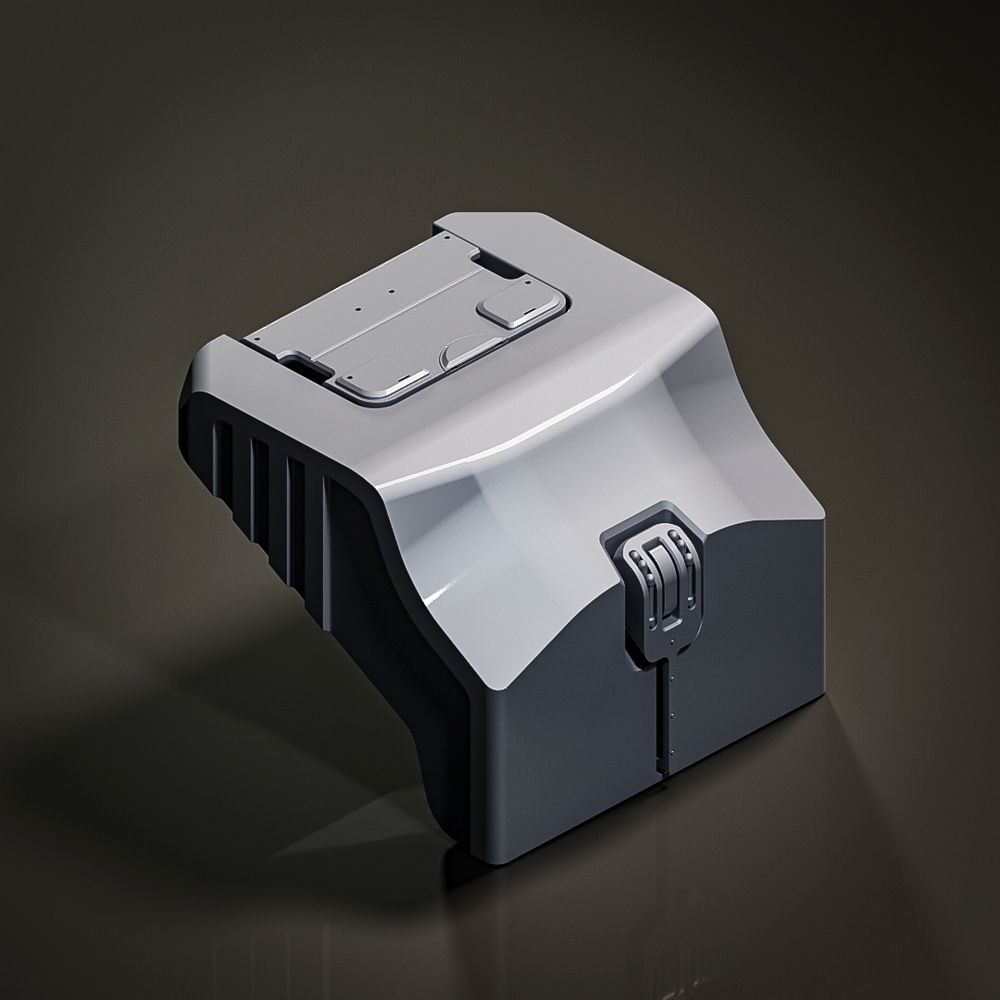 A compact, dark gray industrial piece with a sleek, curved top and a rectangular panel on its surface. Ridges along one side add texture, and a small, hinged element on the front suggests a latch or connector. The piece has a matte finish that contrasts with subtle highlights, displayed against a dark reflective background.