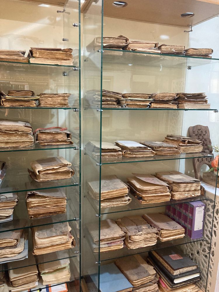 Manuscripts are stored on two glass shelves.