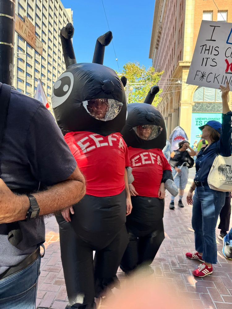Two people dressed in inflatable ant costumes wearing t-shirts with the word “eefa” to humorously represent ant-eefa