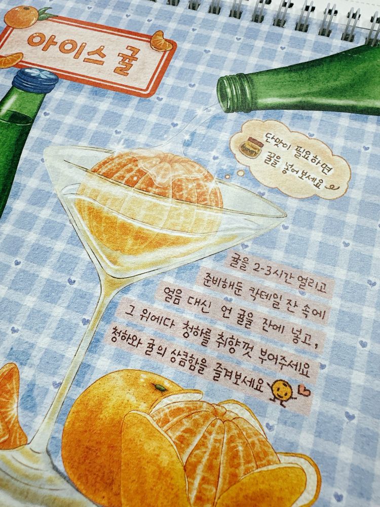 아이스귤 타이틀이 좌측상단에 있고, 타이틀 아래로 청하 그림이 있다. 가운데에 귤이 담긴 칵테일잔이 있고,우측 상단에서 술이 따라지고 있는 청하병이 사선으로 그려져 있다. 우측하단에 반쯤 까진 귤과 껍찔이 안까진 귤 그림이 보인다.