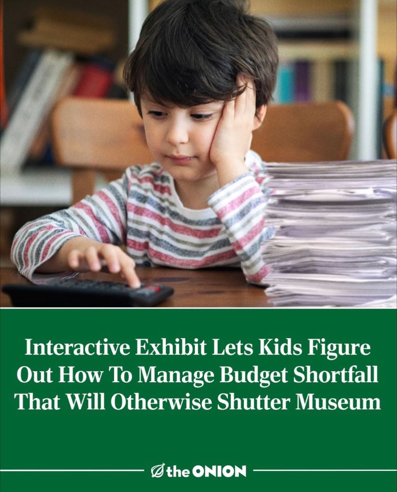 Picture shows a child sitting at a desk. Underneath is white text on a green background which reads "Interactive Exhibit Lets Kids Figure Out How To Manage Budget Shortfall That Will Otherwise Shutter Museum". Image is a pretend headline from the satirist website The Onion.