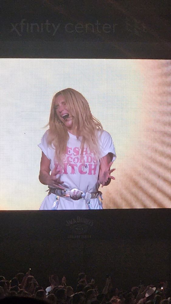 Kesha in a Kesh Records Bitch white and pink shirt belting her lungs out singing Praying in a salute to her freedom.