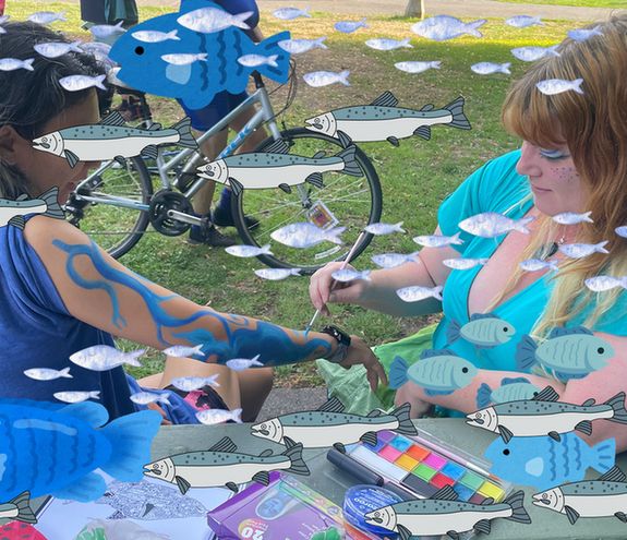 photo of my in blue painting another rider's arm with swirly blue river-esque art, bikers in the background at Laurelhurst Park
lots of fish clip art added