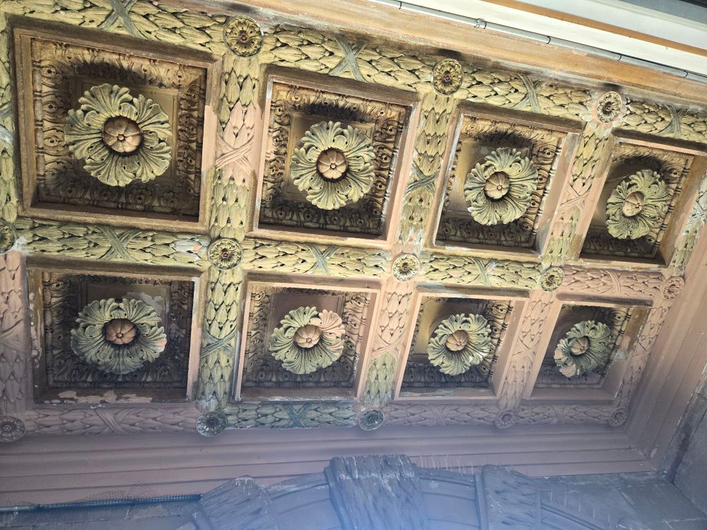 The wooden interior roof of the entryway to the Belle Isle Aquarium showing carved flowers