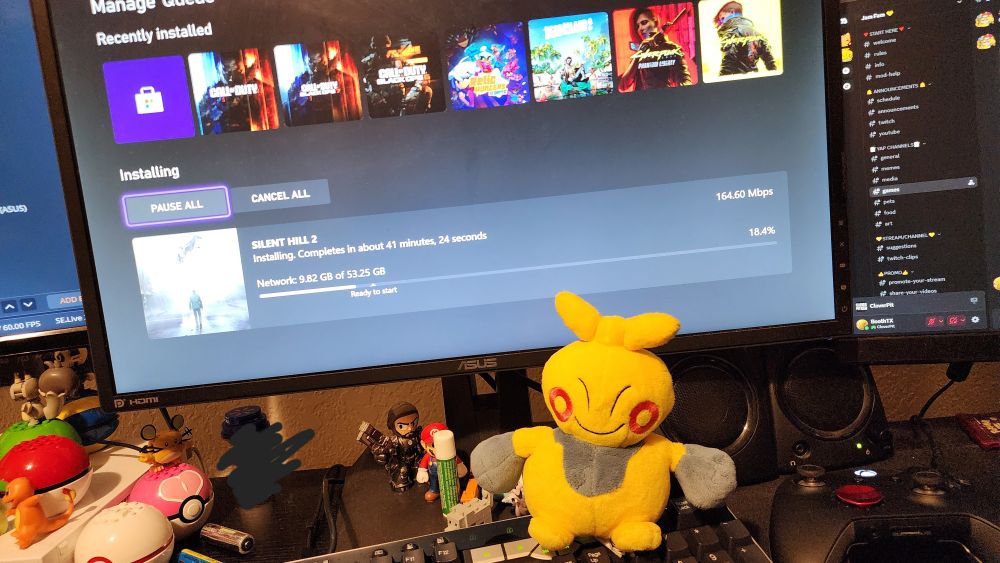 a photo of Makit the Makuhita in front of my monitor. primarily to show off the download progress for the Silent Hill 2 remake. 