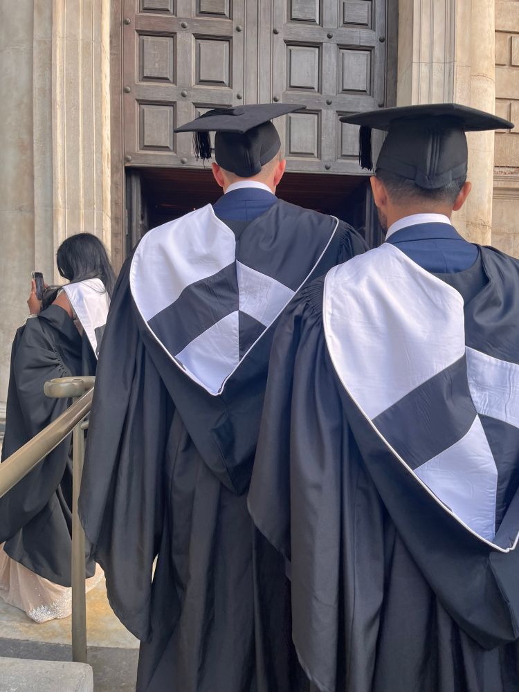 Graduands wearing their BL hoods going into the north entrance of St Paul’s