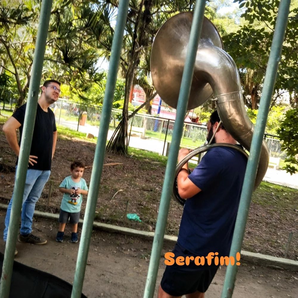 Domingo, praça São Domingos, Niterói, um rapaz ensaia sozinho com sua tuba, pai e filho pequeno assistem.