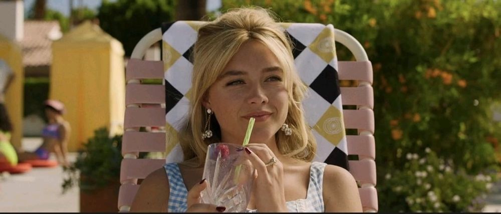 Florence Pugh Bebe um drinque à beira da piscina em still do filme Não se preocupe, querida