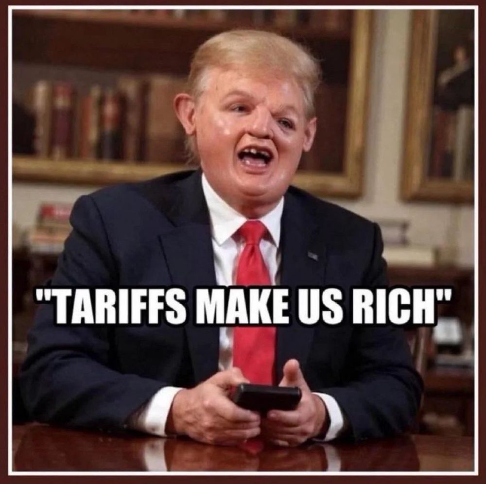 Donald Trump sitting at a desk on his phone. Impact letters across the photo say “tariffs make us rich.” Trump’s head has been morphed into Sloth from Goonies, with one eye sort of sliding off his skull and trying to escape.