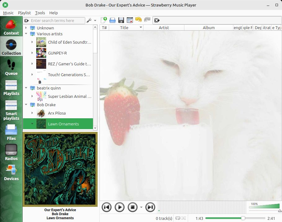 screenshot of Strawberry Music Player, there is a cat licking at a cup of milk in the background
