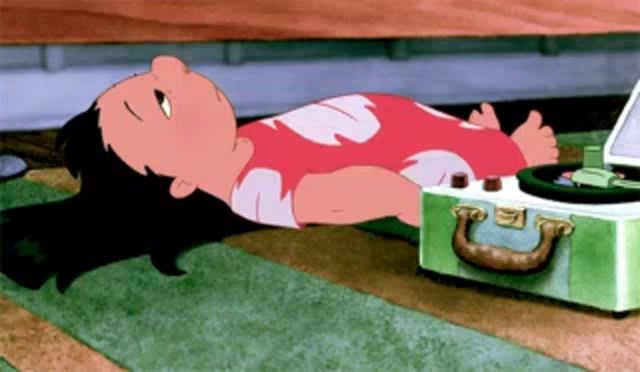 a cartoon character laying on the floor with a record player in the background