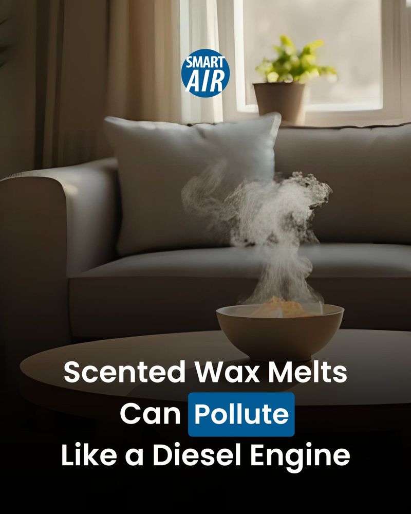 AI-generated image of a cozy living room with a bowl of scented wax melts on a coffee table emitting visible vapor or smoke. A sofa, pillow, and a window with a potted plant are in the background. Text on the image reads: “Scented Wax Melts Can Pollute Like a Diesel Engine.” The logo "SMART AIR" appears at the top.