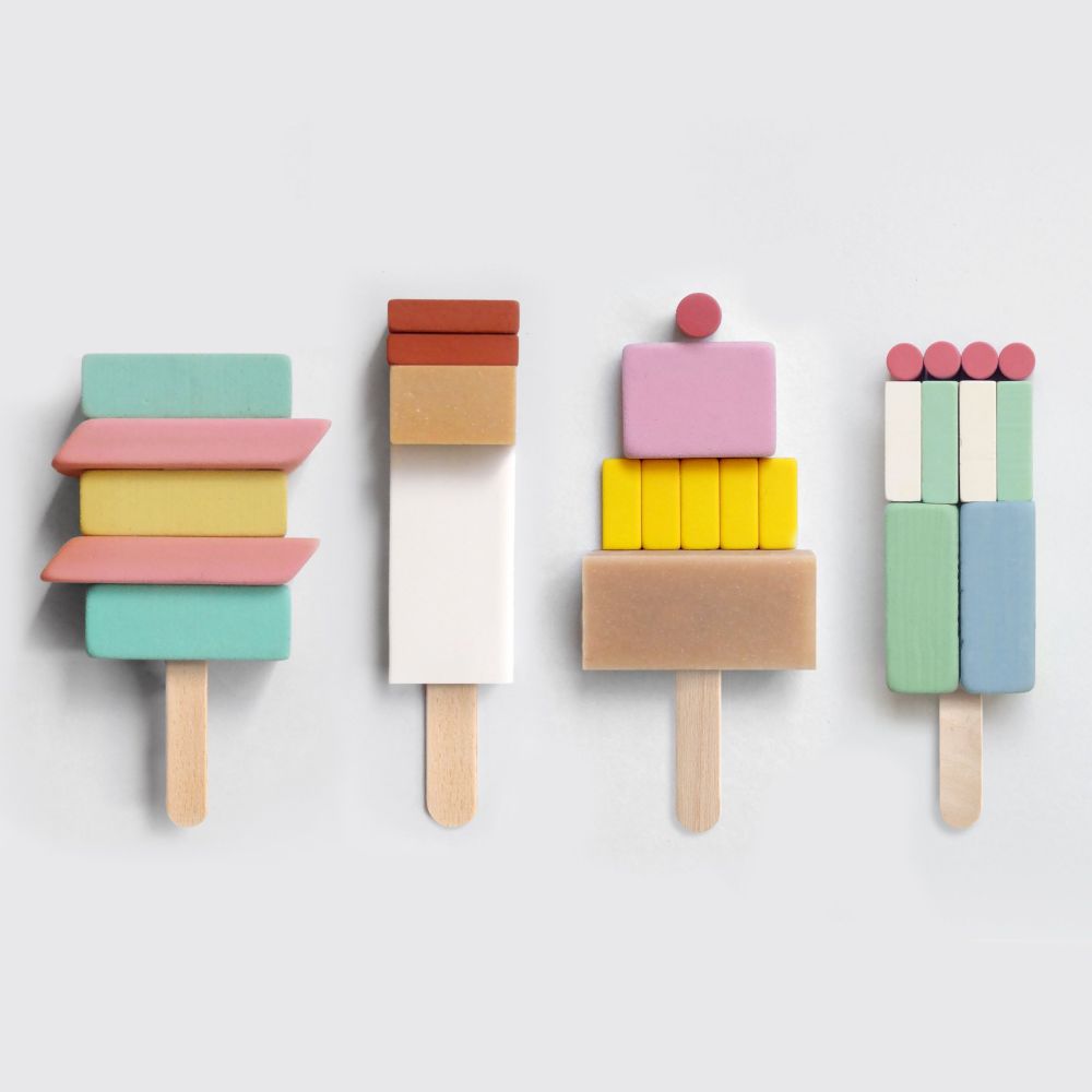 Four popsicles made of erasers of varying colours. They are stacked vertically on top of popsicle sticks so they look edible. 