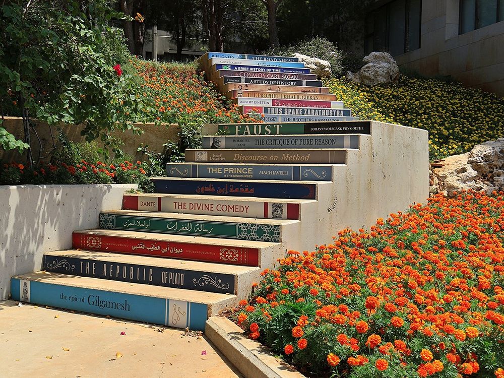 A set of concrete steps that are painted to look like varying book spines 