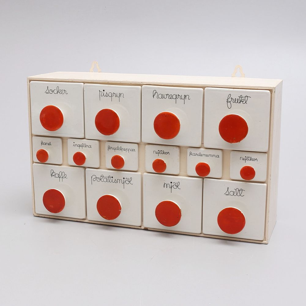 white ceramic drawers with large red circular handles/pulls. The typeface labelling the contents is a lovely script 