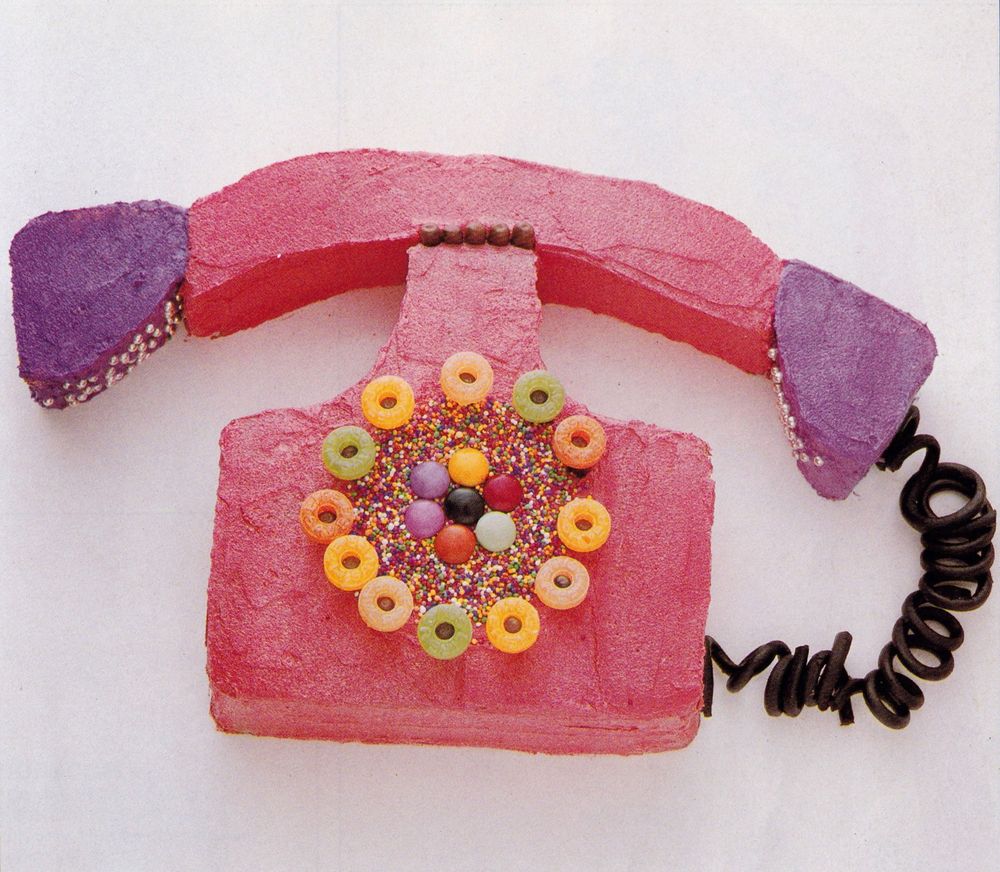 A pink and purple phone cake, with dial made from fruit Polo sweets, Smarties & sprinkes. The phone cable is spiral licorice