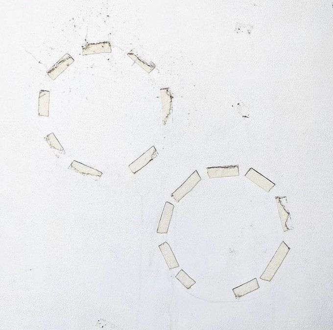 the remants of tape strips in circular shapes, leave two dotted outlines. 