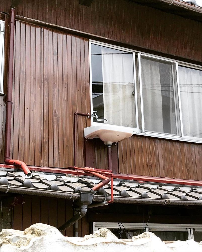 a sink and tap/faucet sit on the outside of a building and on the first floor 