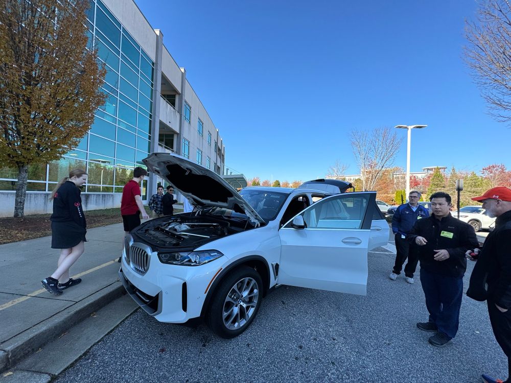White BMW X5 with students outside school