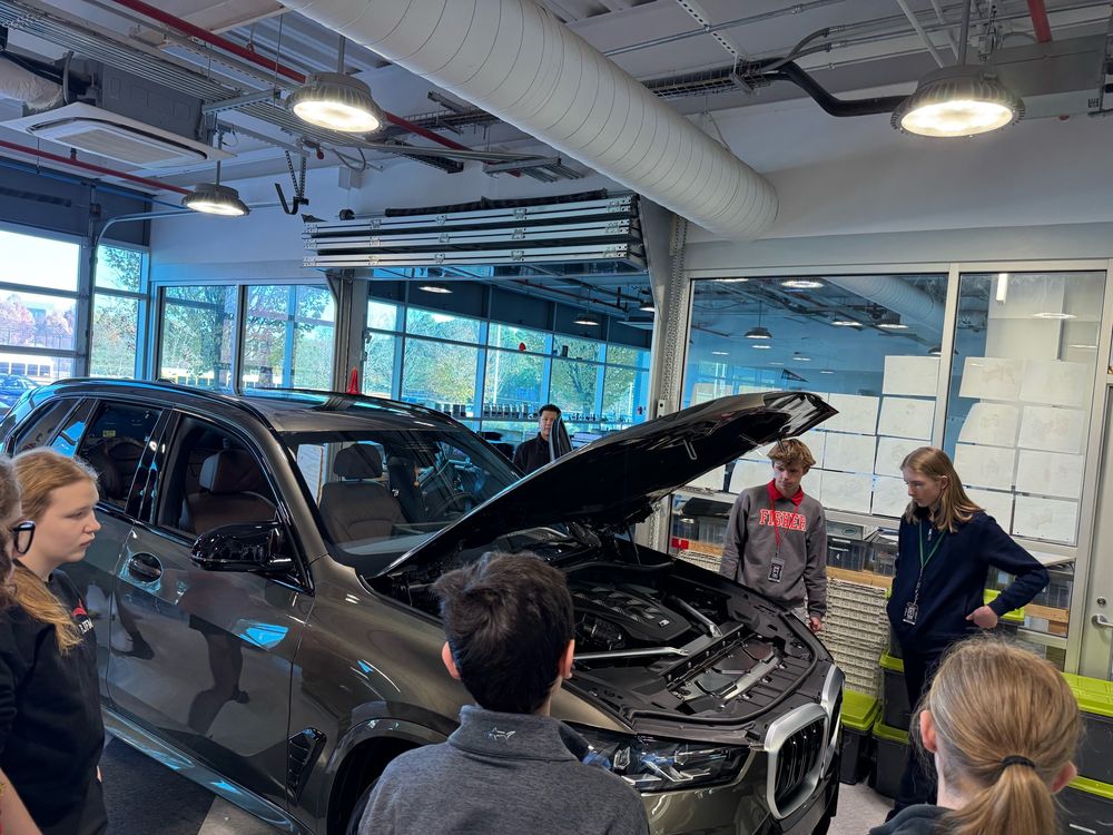 Students exploring a BMW X5, 8 cylinder engine.