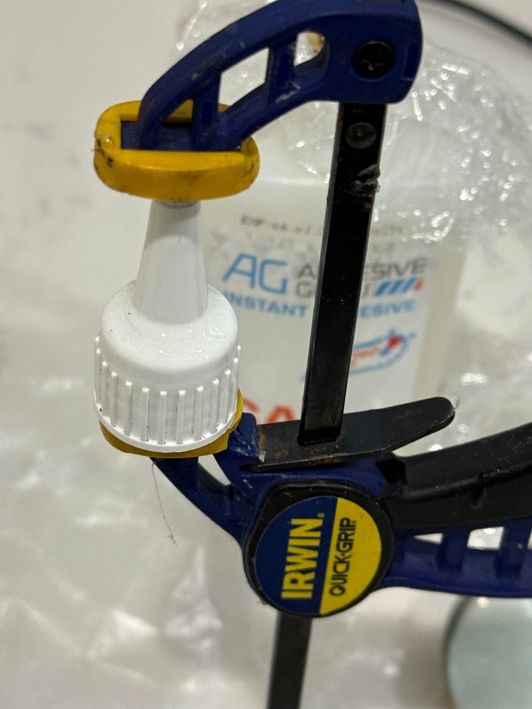 CA bottle cap held in an Irwin Quick Grip clamp. A ring of epoxy around the cap where it separated 