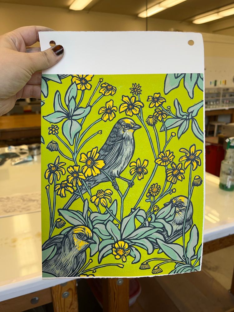 Hand holding a print of birds on a lime green background 