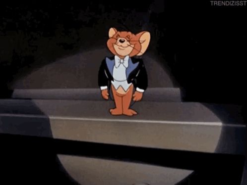 jerry from tom and jerry is wearing a tuxedo and standing on a stage