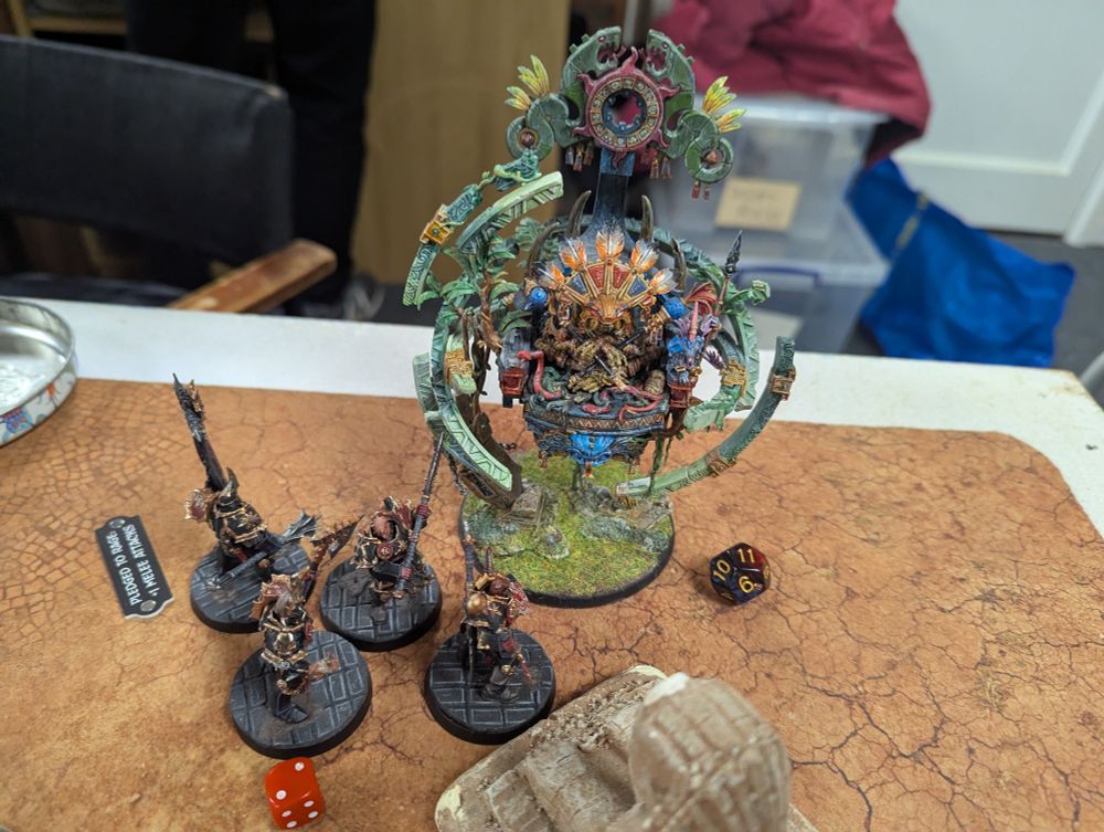 Four Chaos Chosen are fighting Lord Kroak, who has taken eleven wounds.
